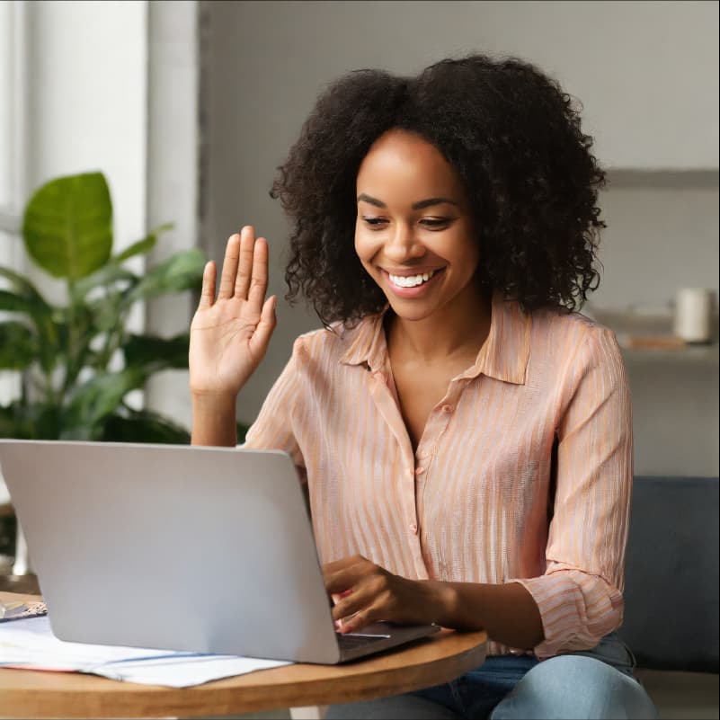 Photo d'une femme souriante en séance de coaching en visio-conférence