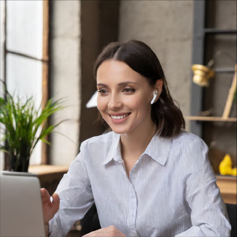 Photo d'une femme souriante en séance de coaching en visio-conférence